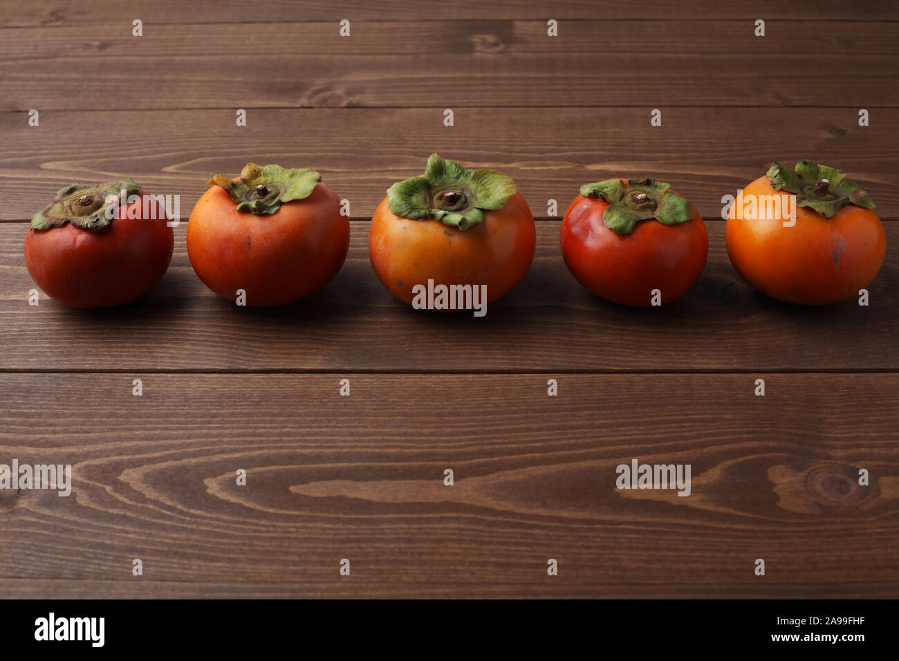 ripe persimmon isolated on wood table Stock Photo