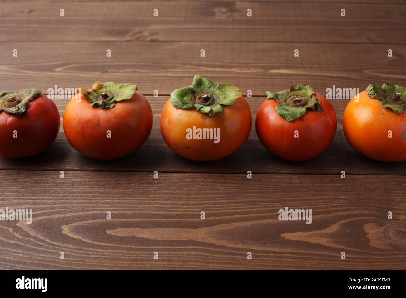 ripe persimmon isolated on wood table Stock Photo