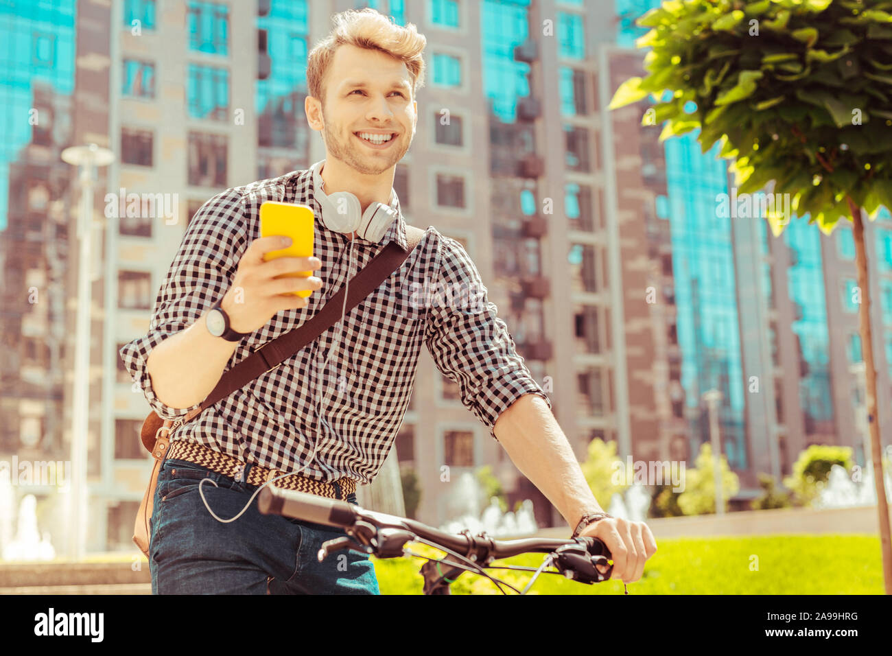 Dreamy young man reading message from his partner Stock Photo