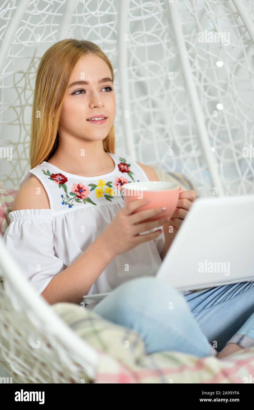Beautiful cute girl using laptop at home and posing on swing Stock ...