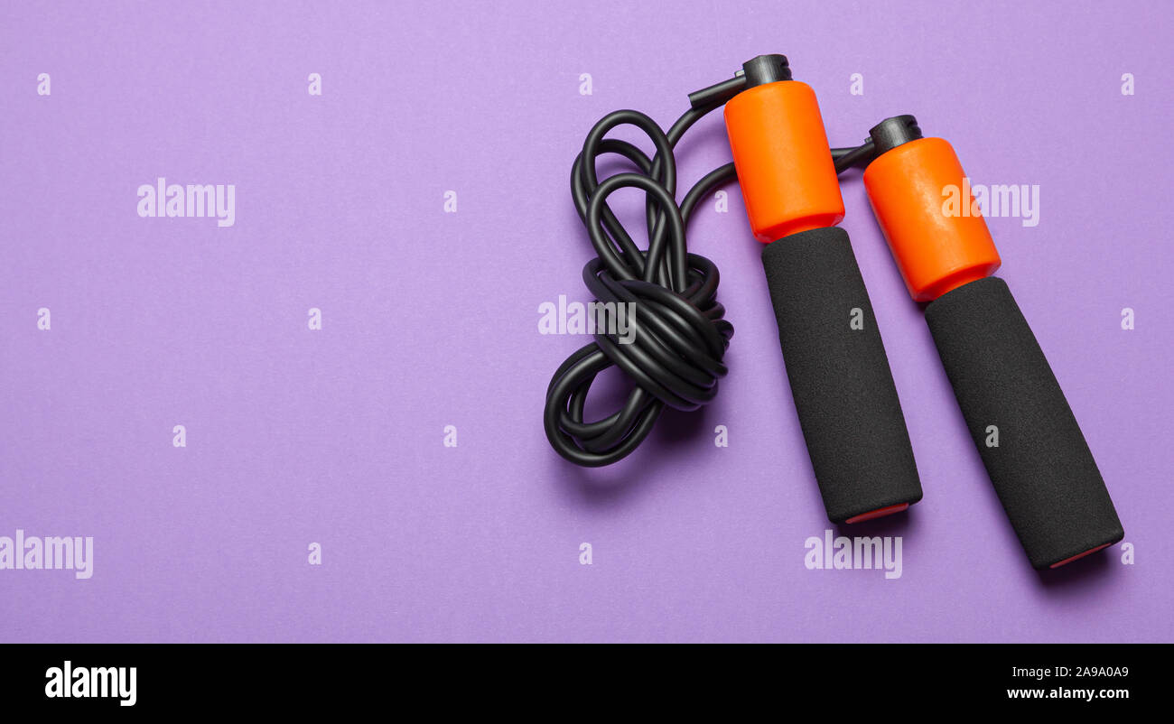 Jump rope. Fun exercises for body health. Orange rope with black cord ...