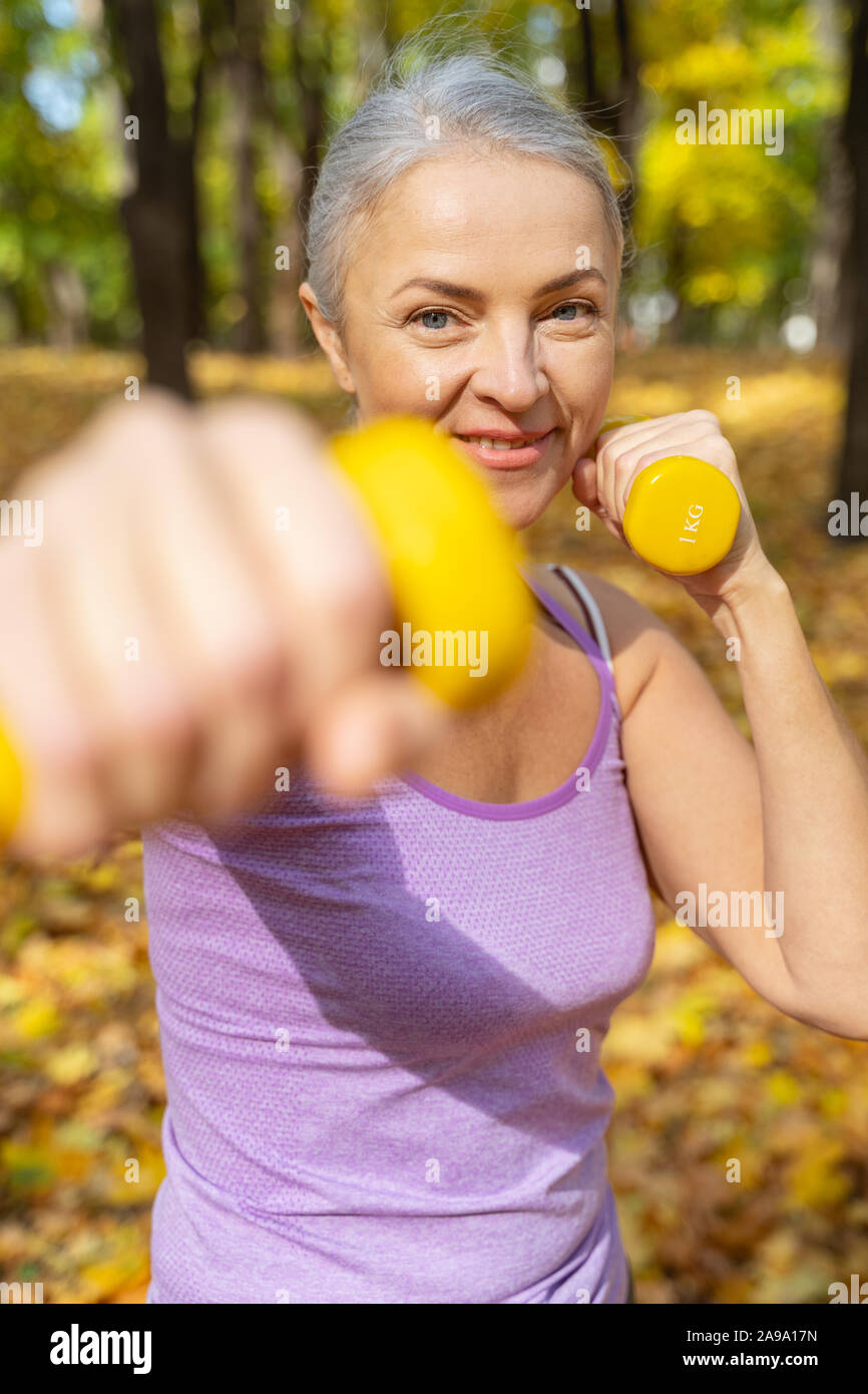 Fit mature lady doing upper body exercises Stock Photo