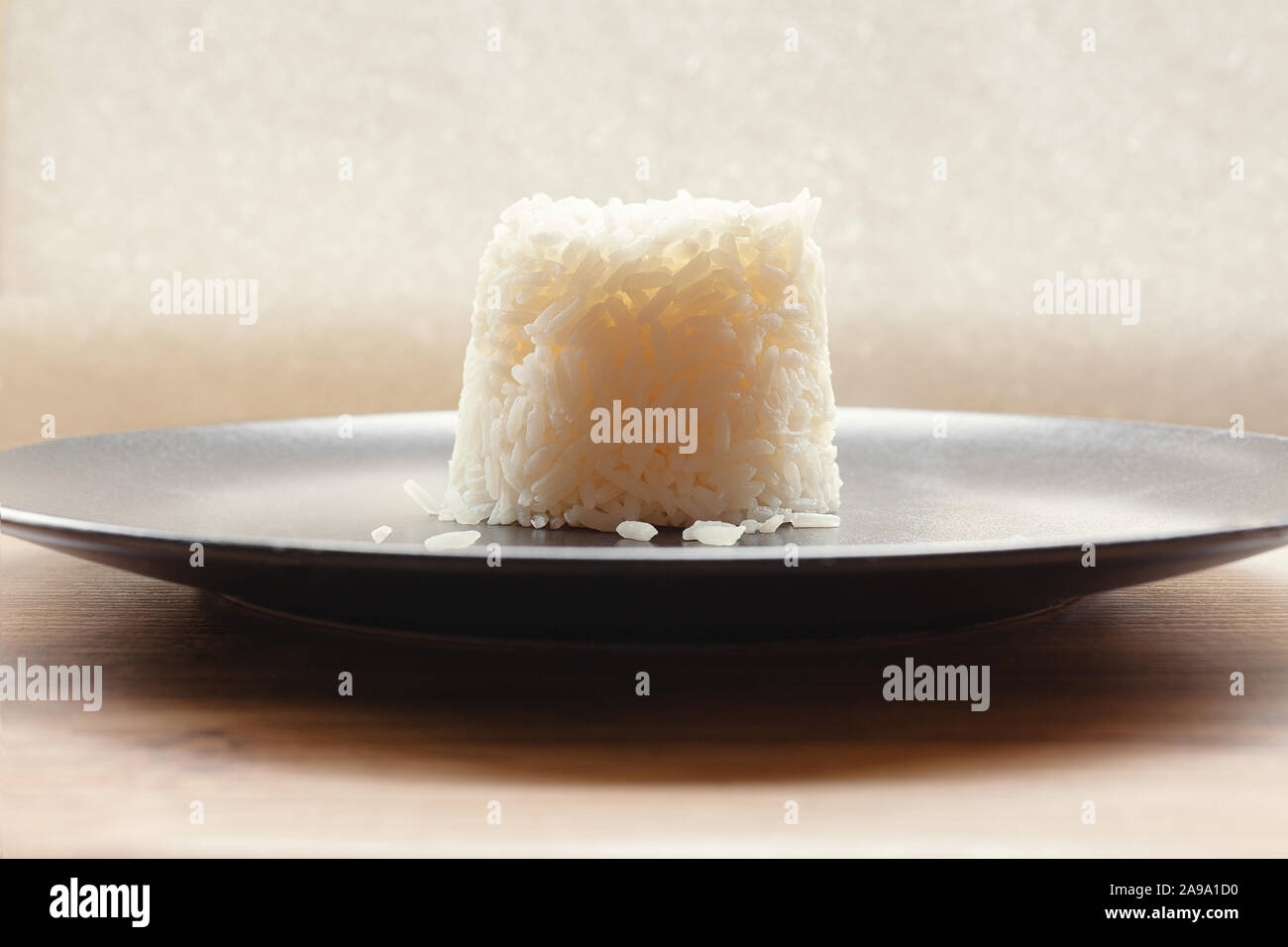 Molded serving of cooked basmati white rice on a elegant black plate