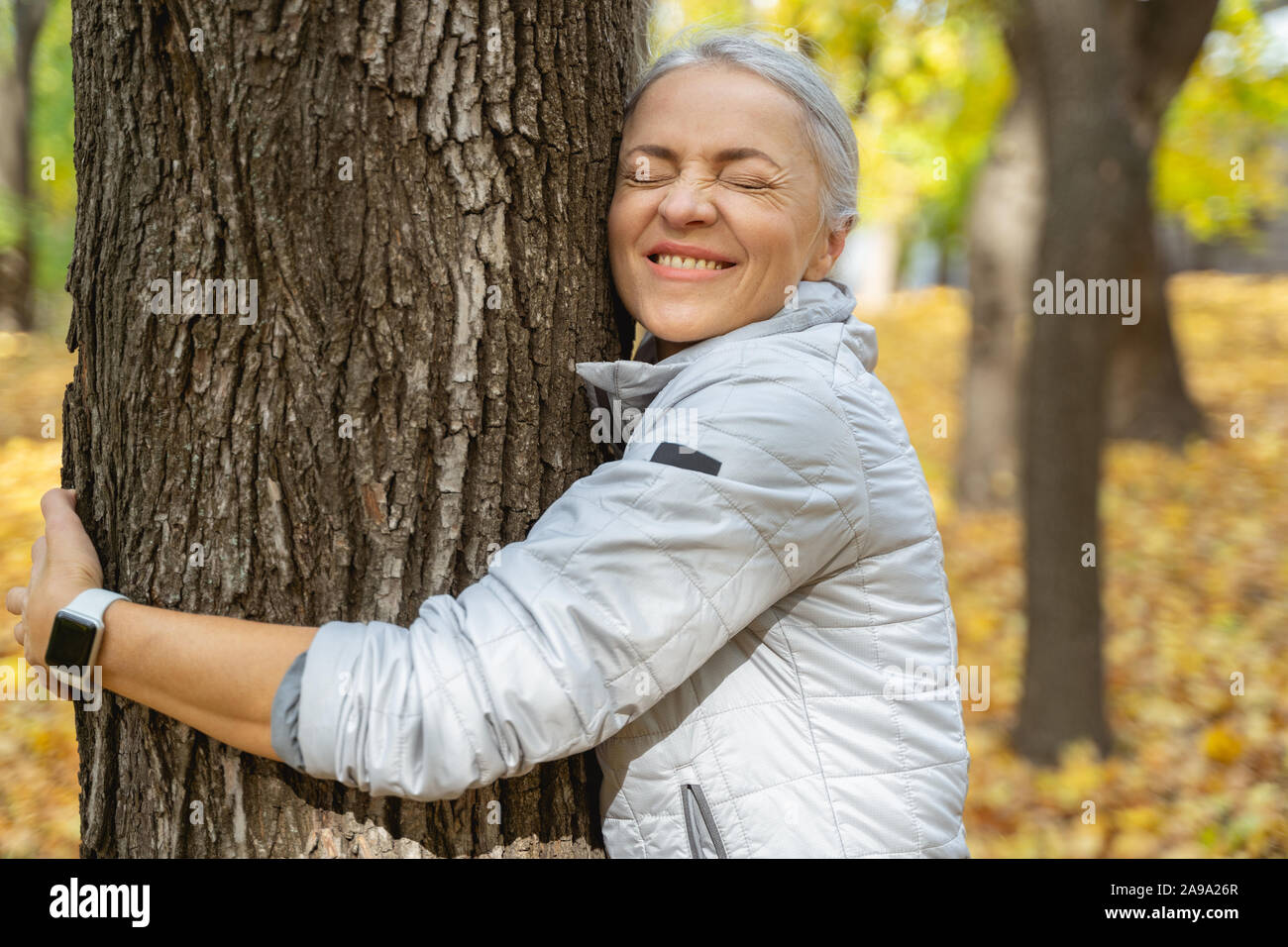 Mature woman embracing tree eyes hi-res stock photography and images ...