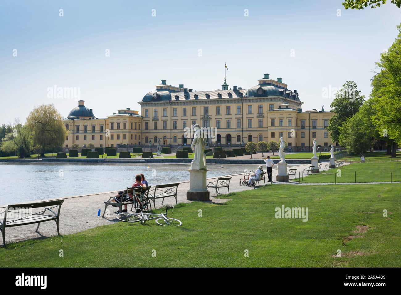 Stockholm Palace, view in summer of tourists sitting on benches facing Drottningholm Palace (Drottningholms Slott) - on Lovön island, Sweden. Stock Photo