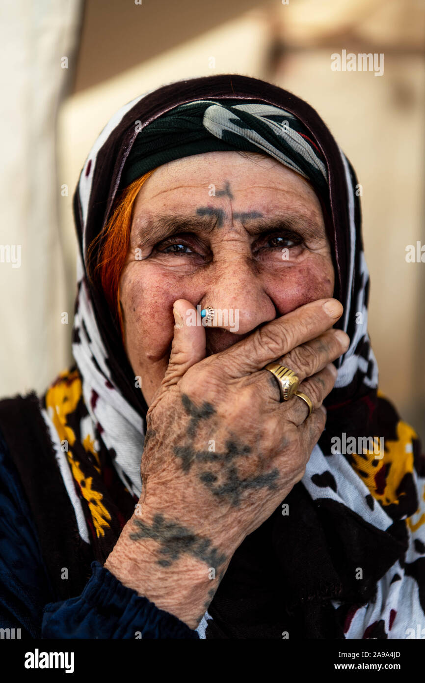 BADARASH, IRAQ - NOVEMBER 7 :  Erdahan, sits in front of her tent on the Bardarash refugee camp. Stock Photo