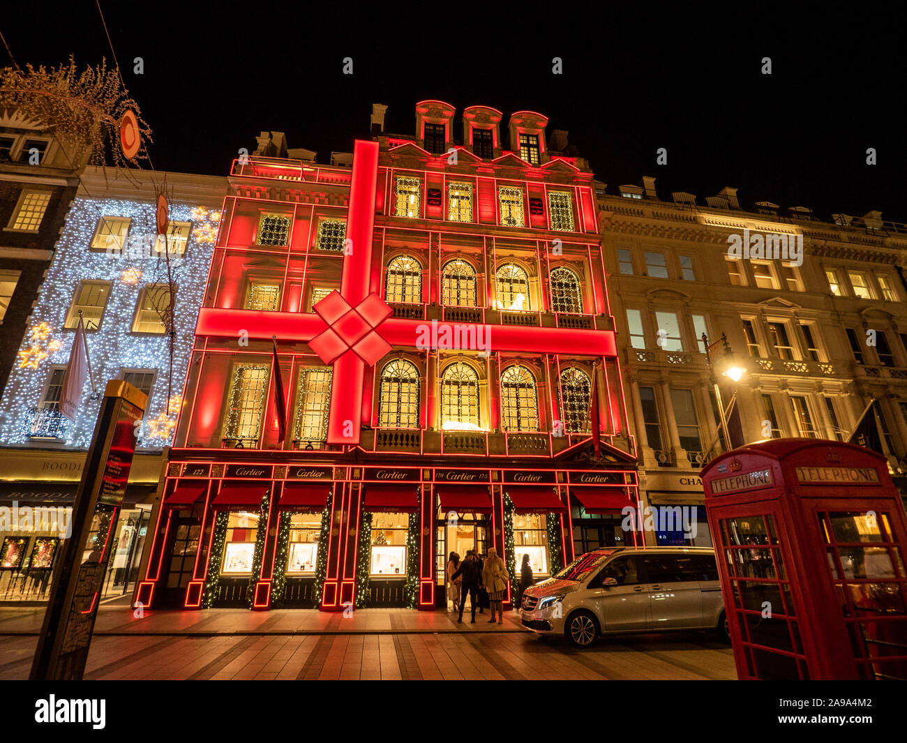 Christmas decorations on New Bond Street in London with the red facade of Cartier. Stock Photo