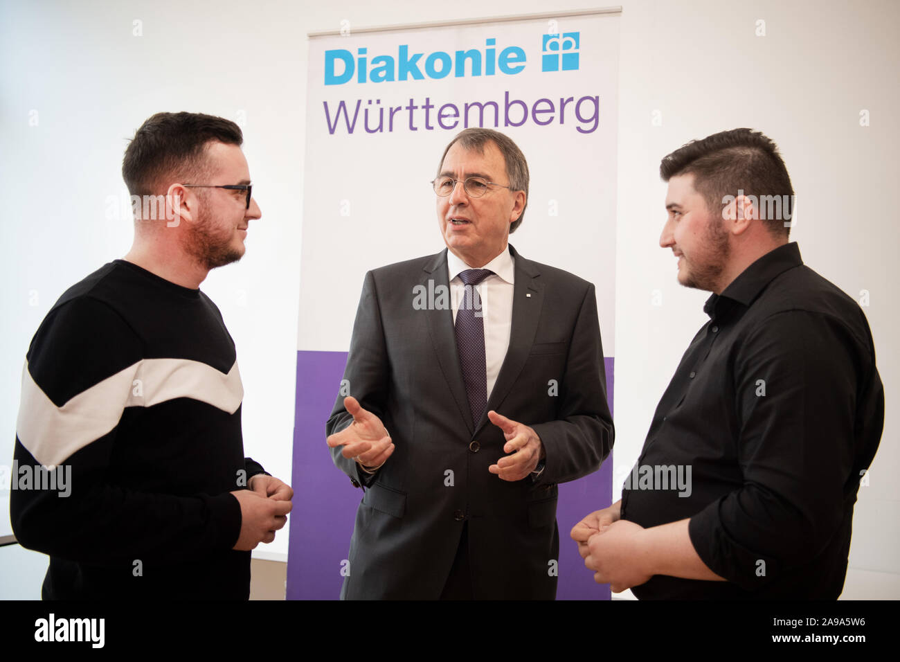 Stuttgart, Germany. 14th Nov, 2019. Ruzhdi Canaj (l) and Ferdinand Dedaj (r) speak with Dieter Kaufmann, CEO of the Diakonisches Werk Baden-Württemberg. Since 2015, more than 260 young Kosovars have begun training in nursing care for the elderly at Baden-Württembergische Diakonie, the welfare association of the Protestant Church. Credit: Tom Weller/dpa/Alamy Live News Stock Photo