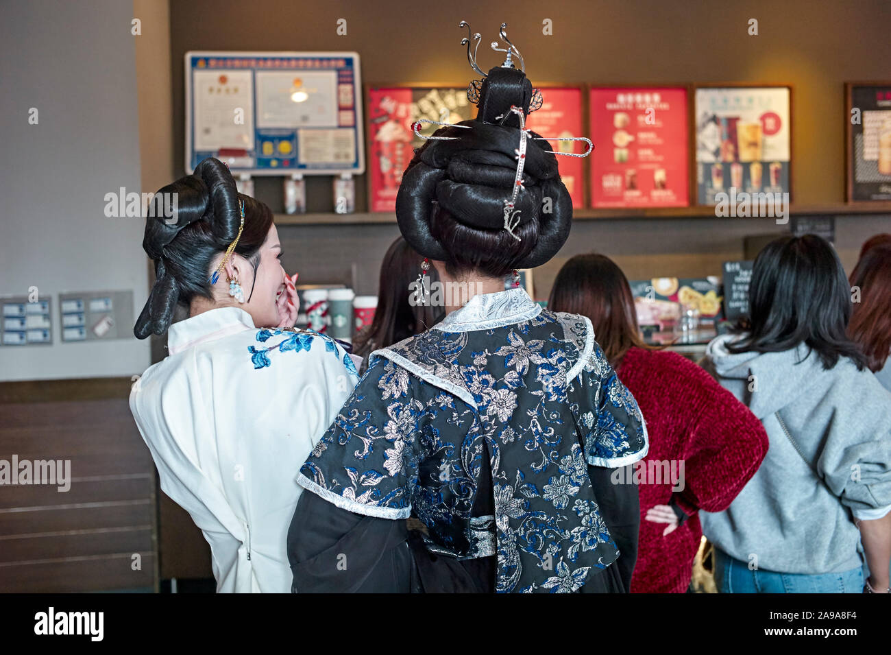 Traditional Chinese dressed female waiting in line at Starbucks coffee in Lishui, Zhejiang Province China, Stock Photo