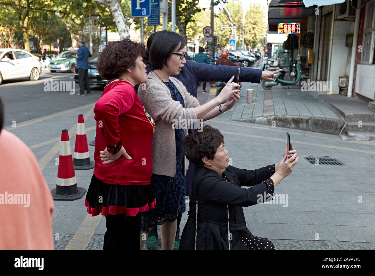Female Chinese locals take photographs posing for Wechat, Lishui, Zhejiang Province China, Stock Photo