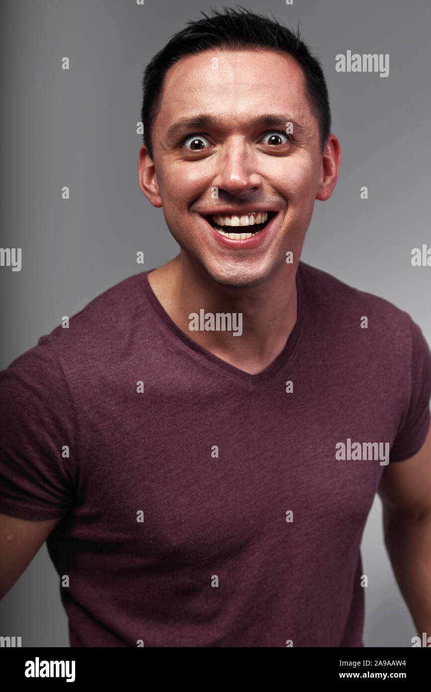 Angry mad crazy man shouting the wide opened eyes and anger smile. Closeup emotion bright portrait Stock Photo