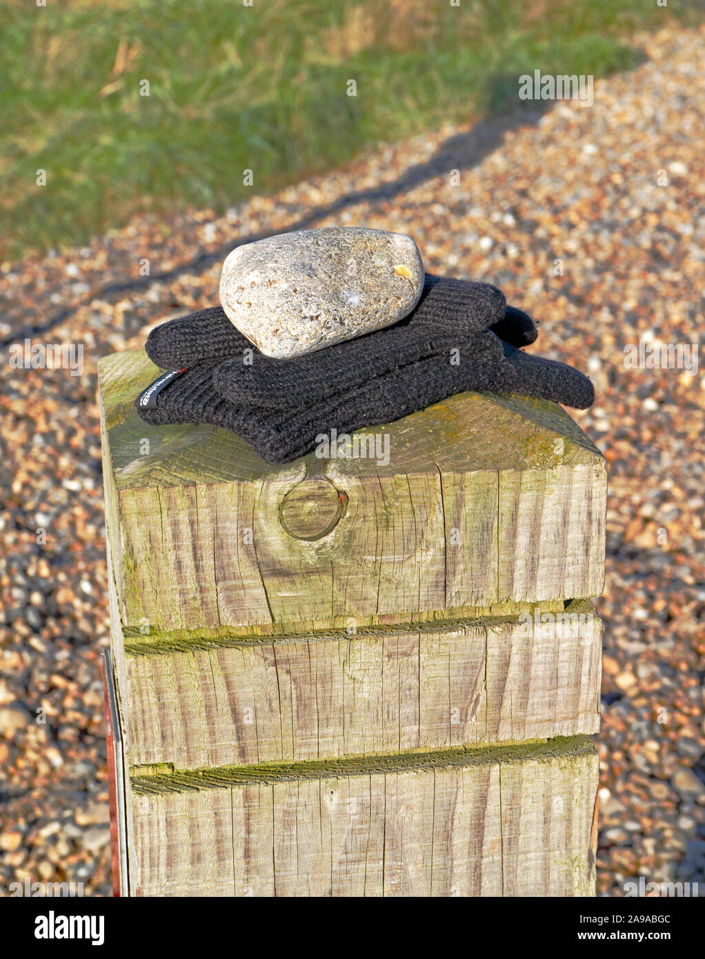 A pair of lost gloves on a wooden post by the beach in North Norfolk at Salthouse, Norfolk, England, United Kingdom, Europe. Stock Photo