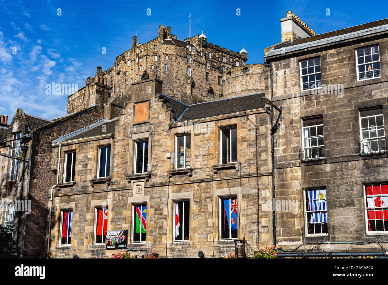 Close up Detail of Historic Buildings in the Grassmarket With View of Edinburgh Castle Towering Above with a Blue Sky #2. Edinburgh, Scotland. Stock Photo