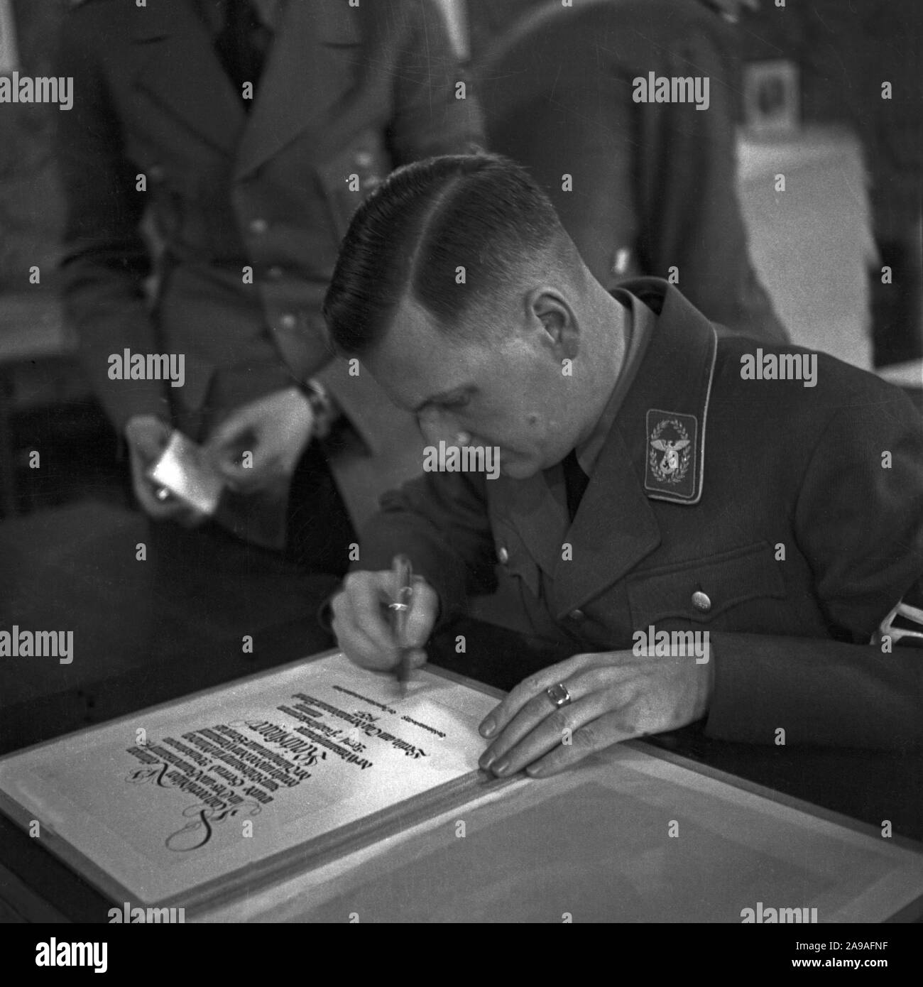 Reichsleiter signing a document, Germany 1930s. Stock Photo
