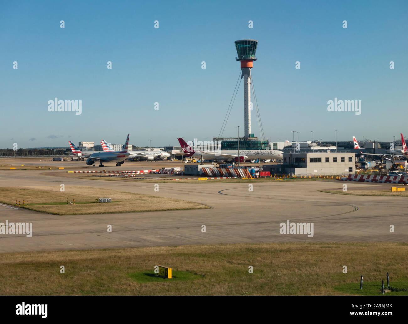 Air traffic control tower and parked aircraft at London Heathrow Airport, England, United Kingdom Stock Photo