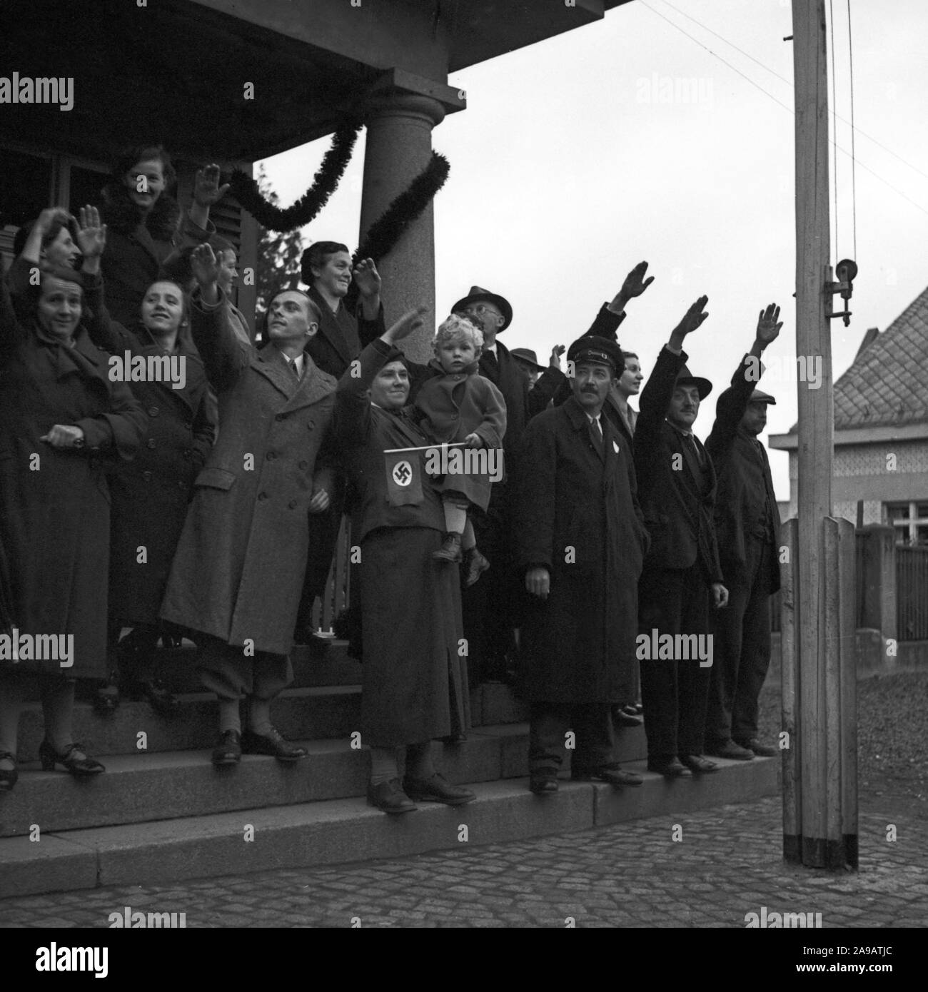 People in the streets cheering to Fuehrer and chancellor Adolf Hitler visiting the city of Asch in Sudetenland county, Germany 1930s. Stock Photo