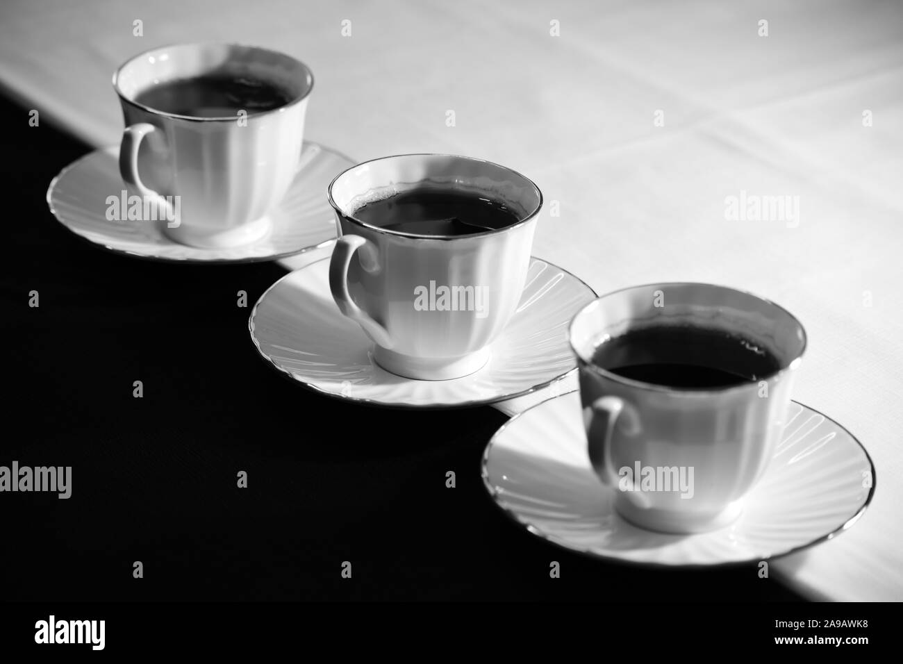 Three cups and saucers with black tea. Stock Photo