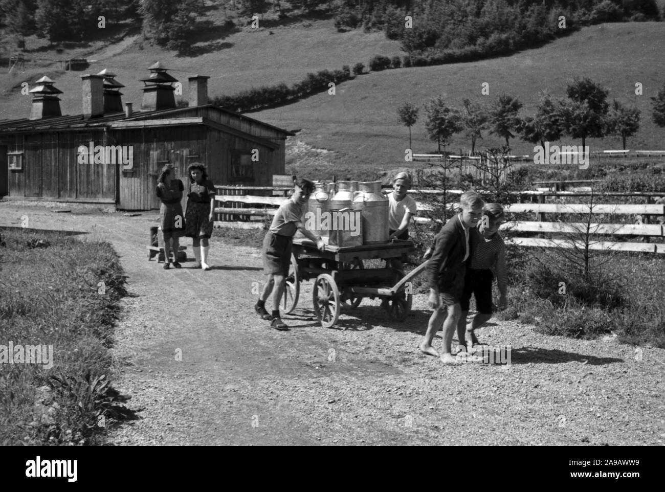 Children fetching milk for home and school lunch, Germany 1940s. Stock Photo