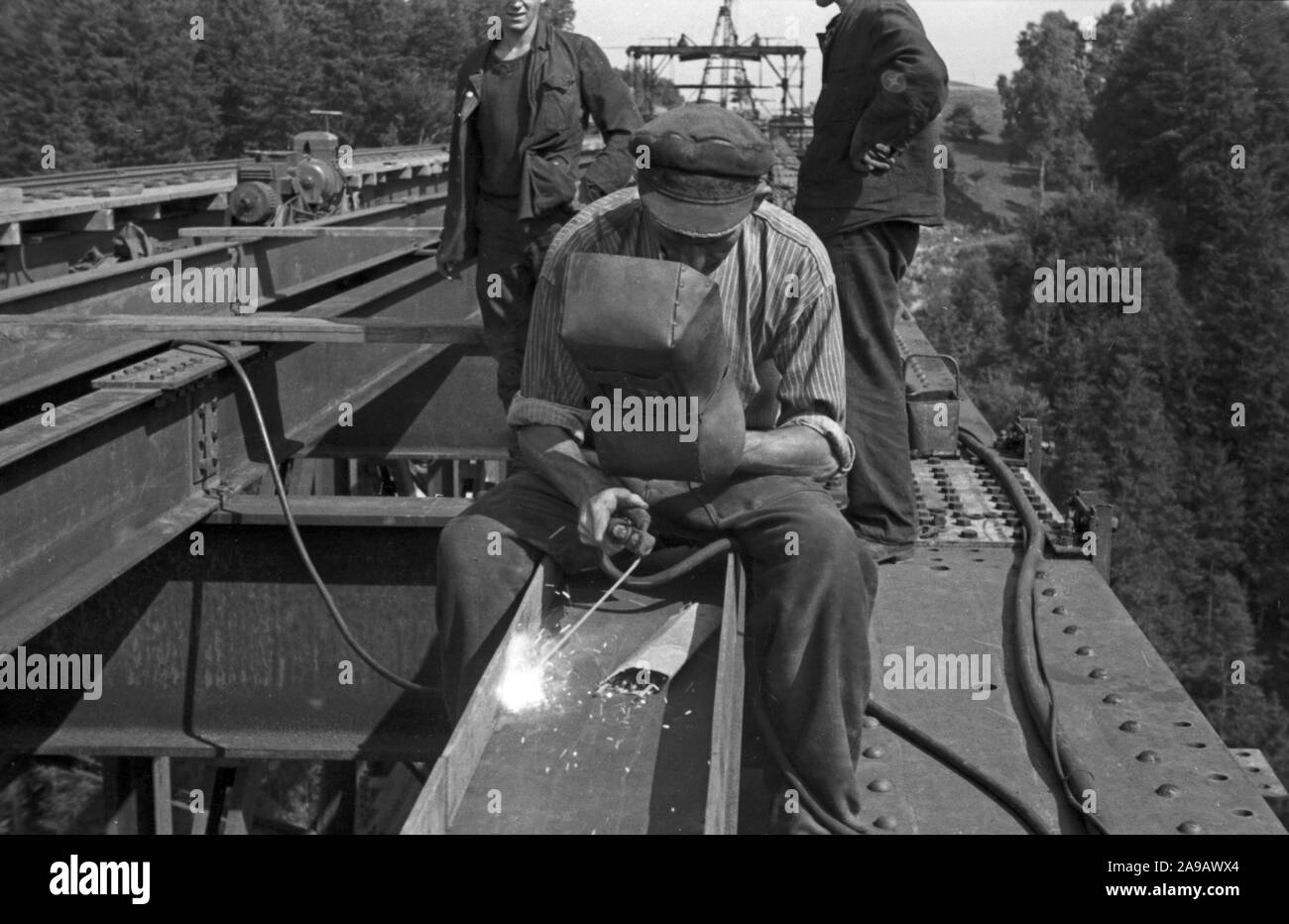 Worker welding on a railway bridge, Germany 1940s Stock Photo Alamy