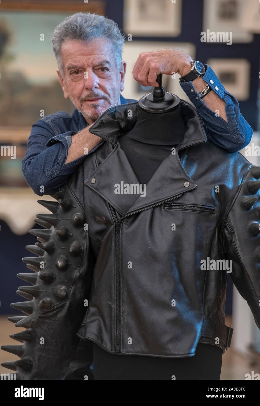 Bonhams, London, UK. 14th November 2019. Nicky Haslam, one of the world’s most celebrated interior designers, attends a photo call at Bonhams for the sale of his impressive collection from the Hunting Lodge in Hampshire, where Haslam has lived since 1978. Image: Nicky Haslam with a Craig Morrison jacket, which will be sold with a Terence Donovan print of Haslam wearing the same jacket in 1992. Estimate: £500-700. Credit: Malcolm Park/Alamy Live News. Stock Photo