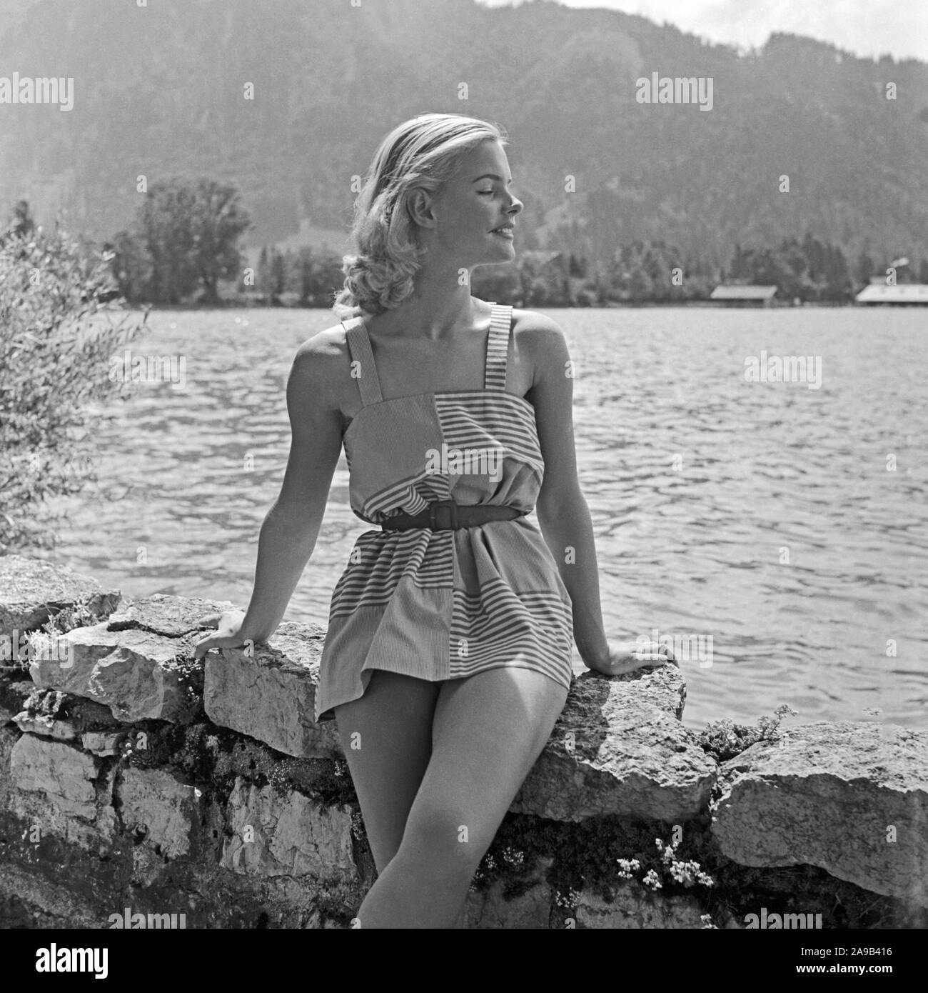 A young woman presenting her latest swimsuit by the shore of a lake, Germany 1957 Stock Photo