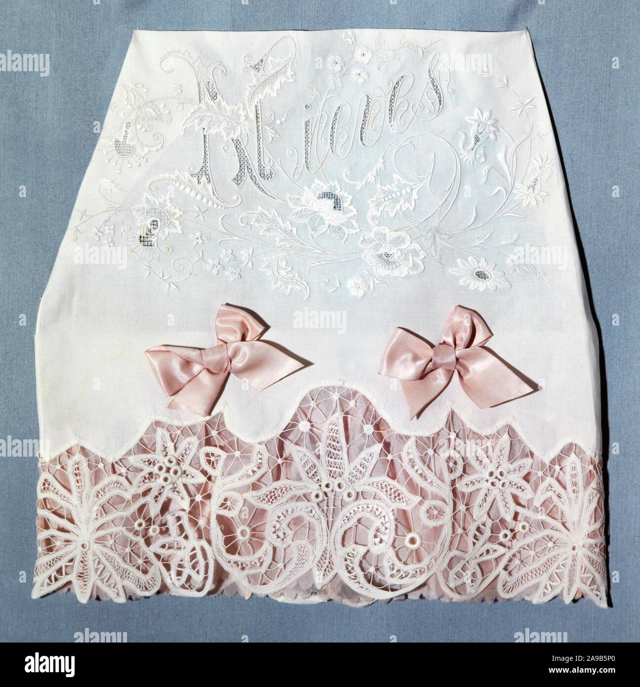 Juego de cama. Lino de color blanco con cinta de seda de color rosa. Bordad ode color blanco. Barcelona, hacia 1900. Stock Photo