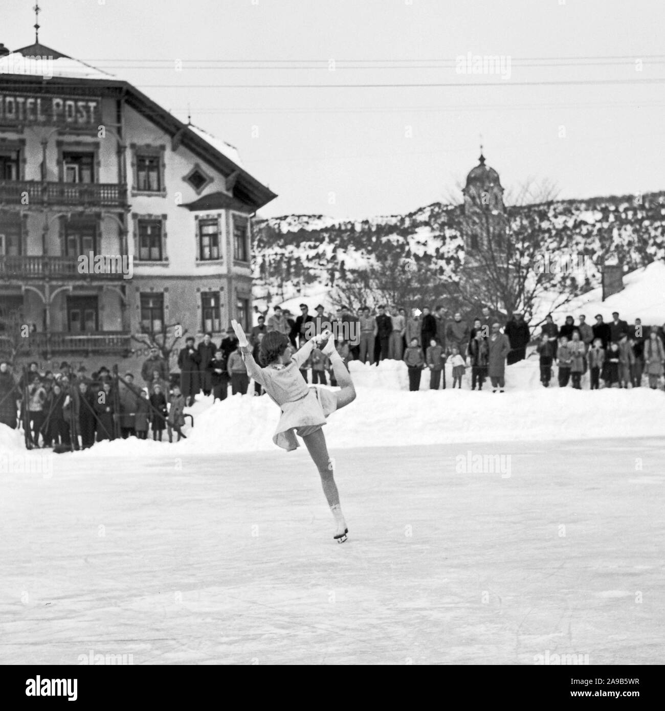 A girl ice dancing in front of a village's audience, Germany 1956 Stock Photo
