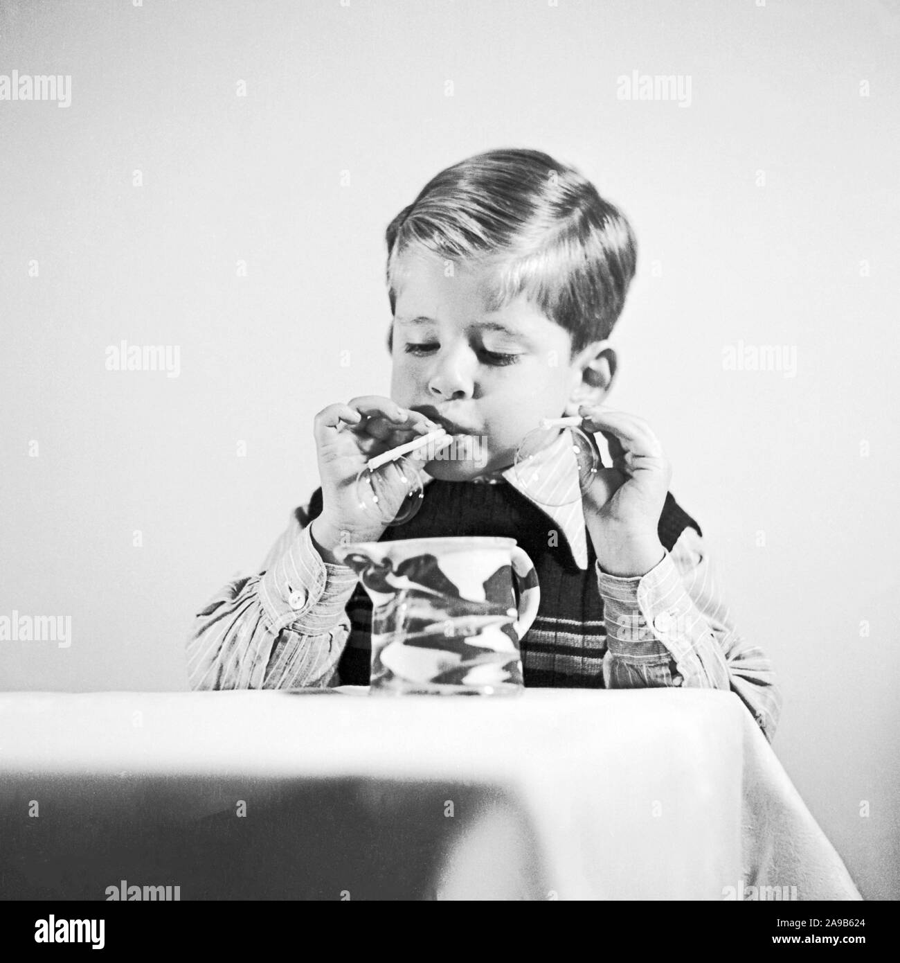 A little boy blowing bubbles, Germany 1951 Stock Photo