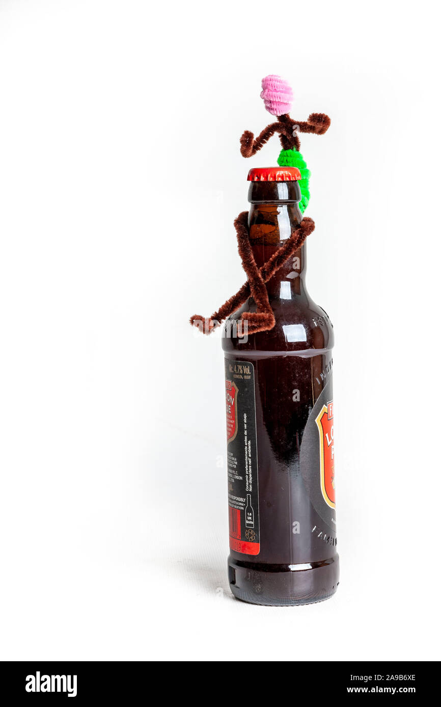 Pipe cleaner figures sitting on a beer bottle Stock Photo Alamy