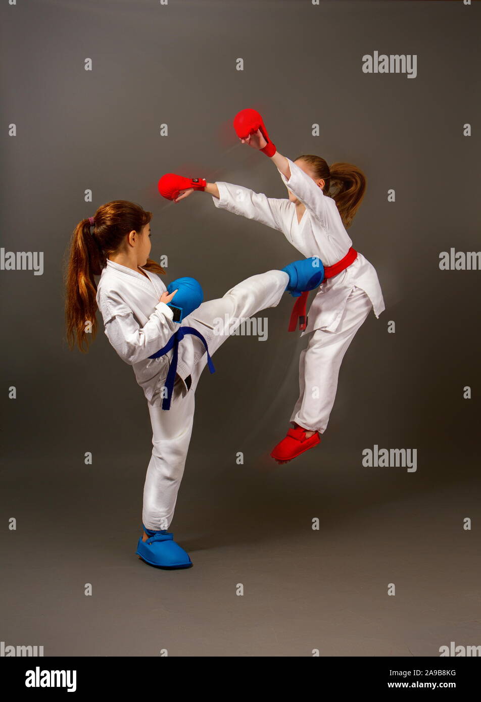 two little karate girls in kimonos and full sports protective gear of
