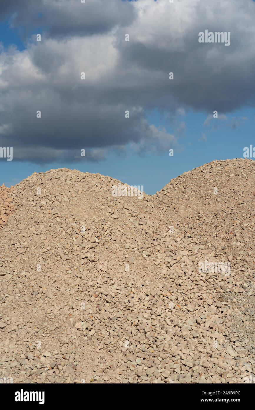 Mountains of sand and stone against a blue sky Stock Photo