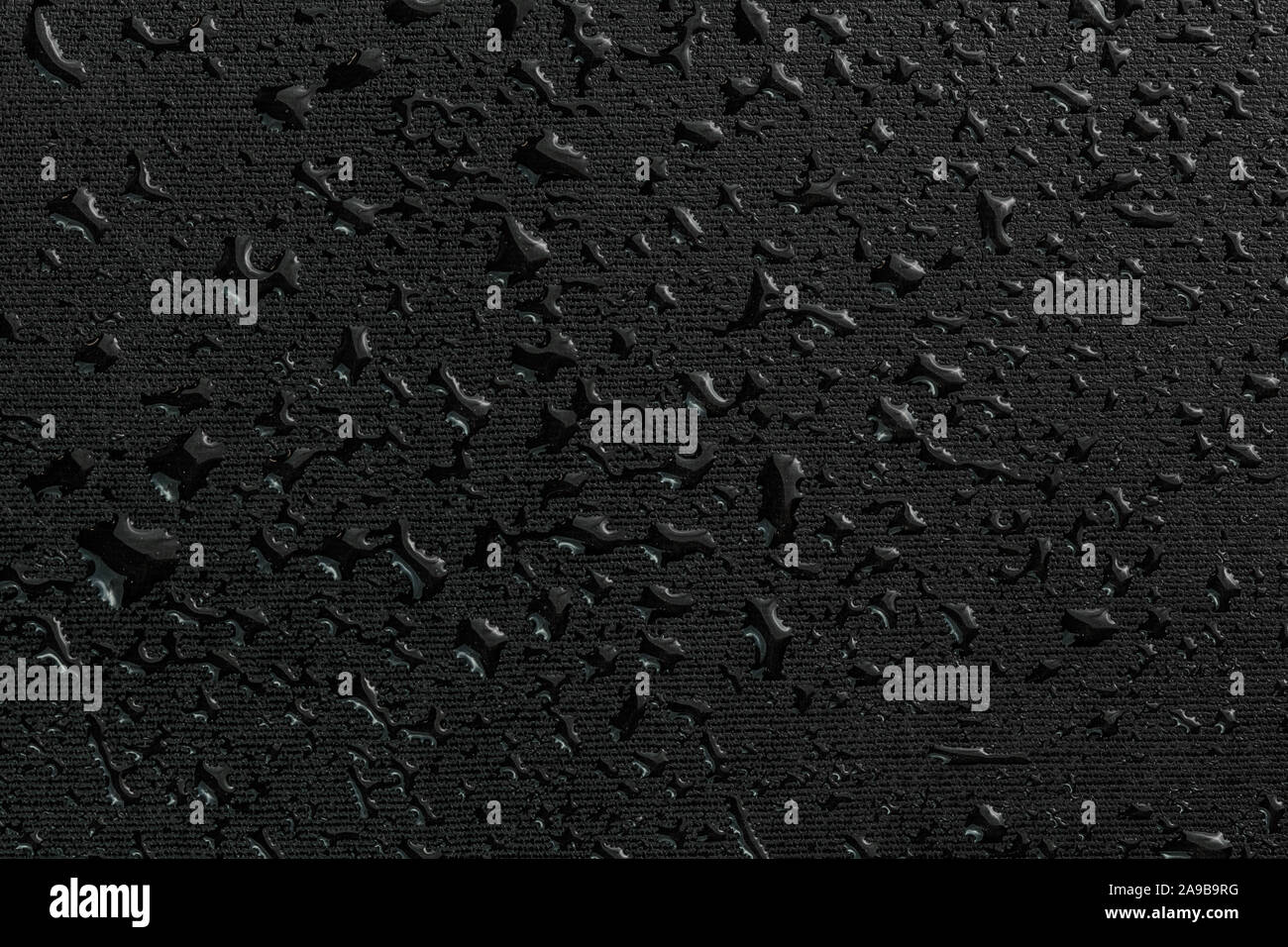 water drops on black flat rubber surface dark macro background Stock Photo