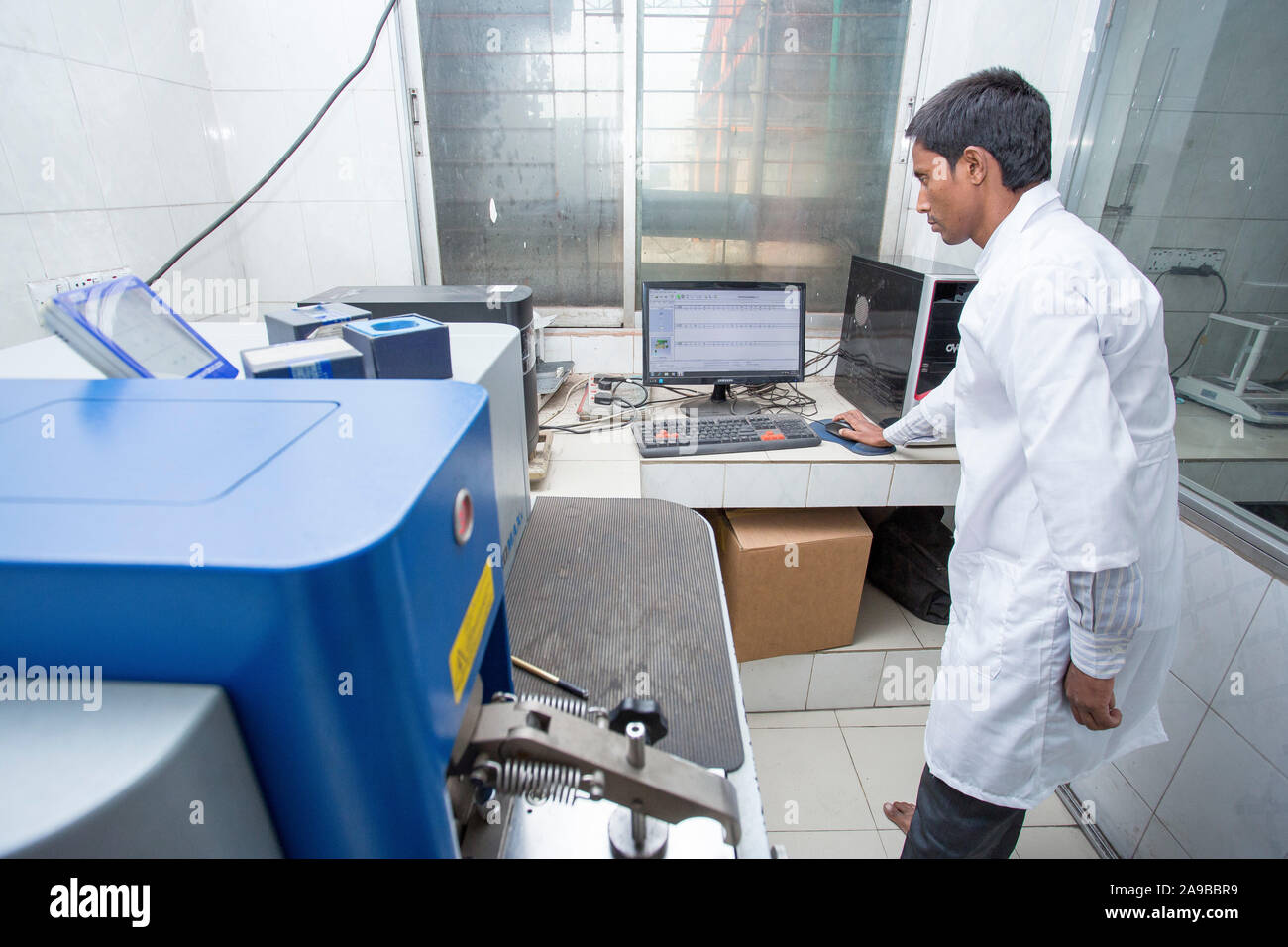 Bangladesh – May 19, 2015: A factory lab operator using Steel rod ...