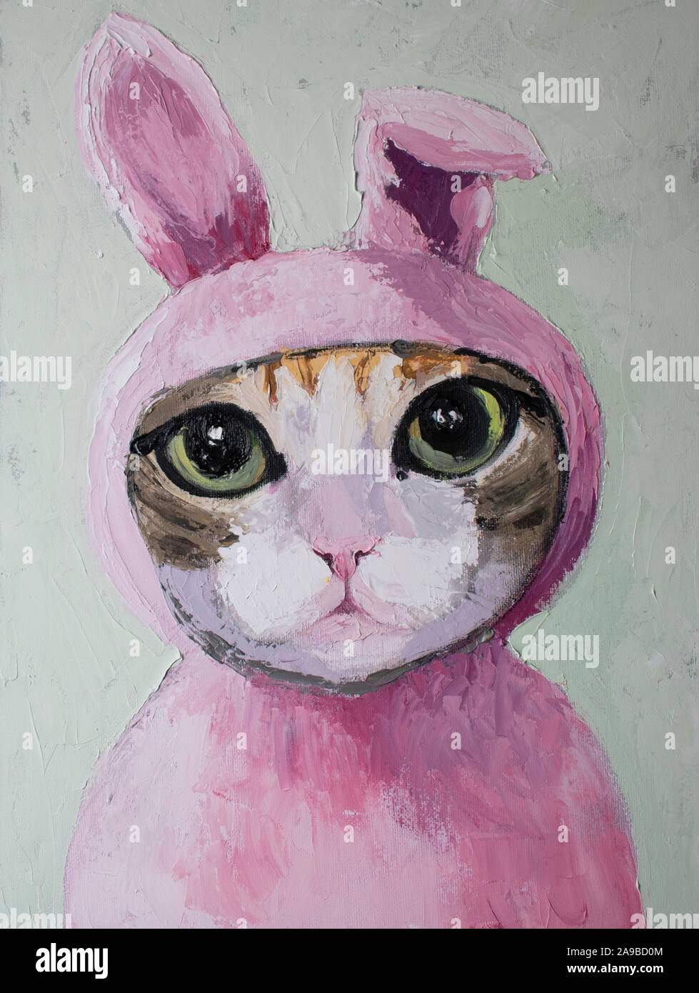 Cute cat with big eyes in fluffy pink rabbit suit Stock Photo