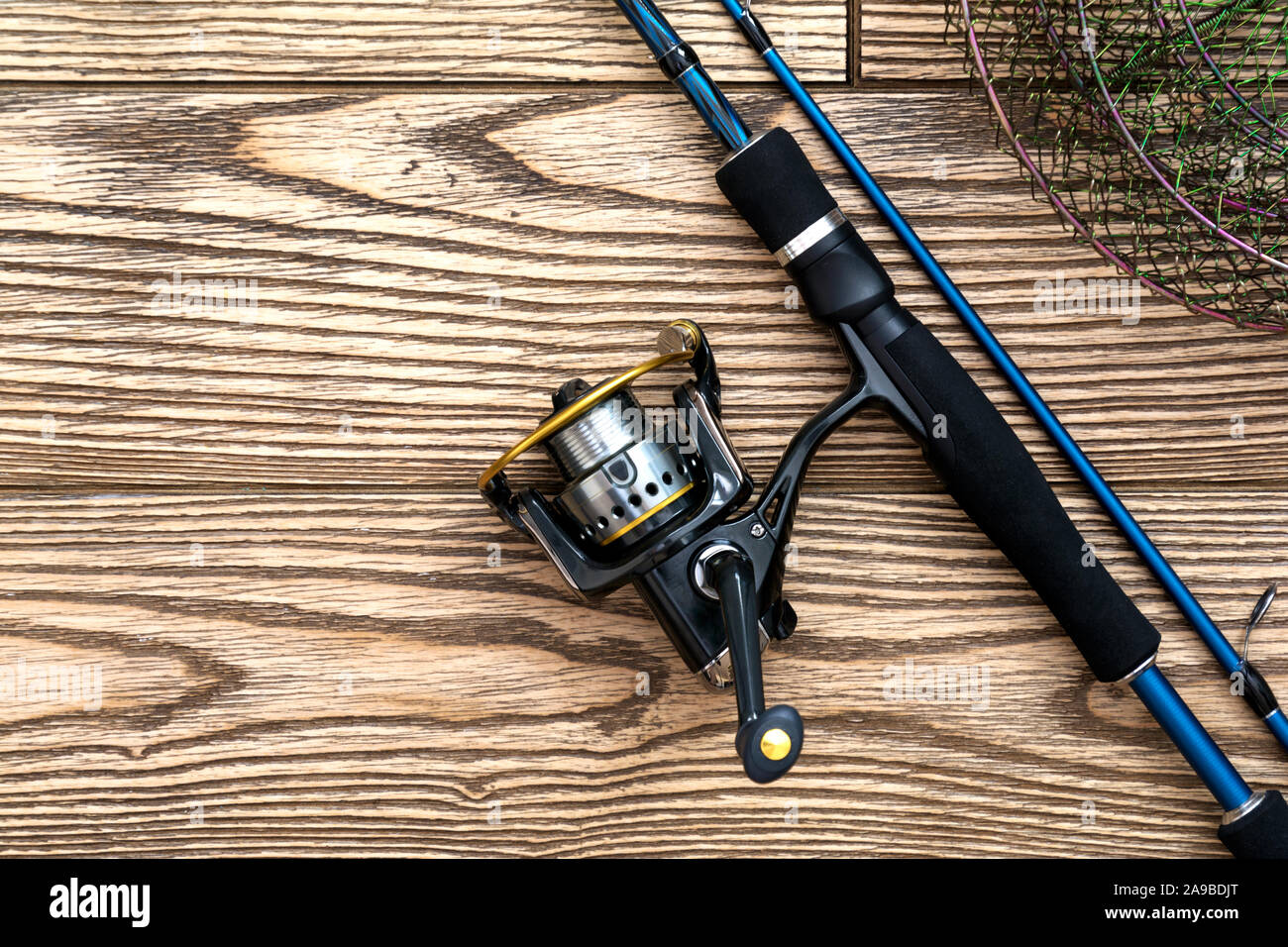 Fishing background. tackle - fishing spinning, reel and metal net on dark  wooden background. Top view. Copy-space Stock Photo - Alamy