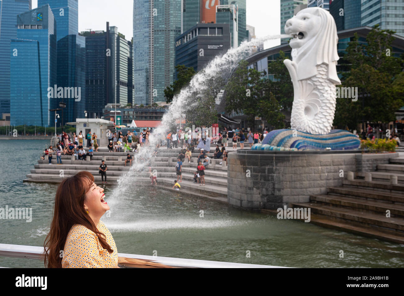 East Asian tourists posing for photos at a small Merlion statue at Merlion  Park, Marina Bay, Singapore; the larger Merlion stands in the background  Stock Photo - Alamy