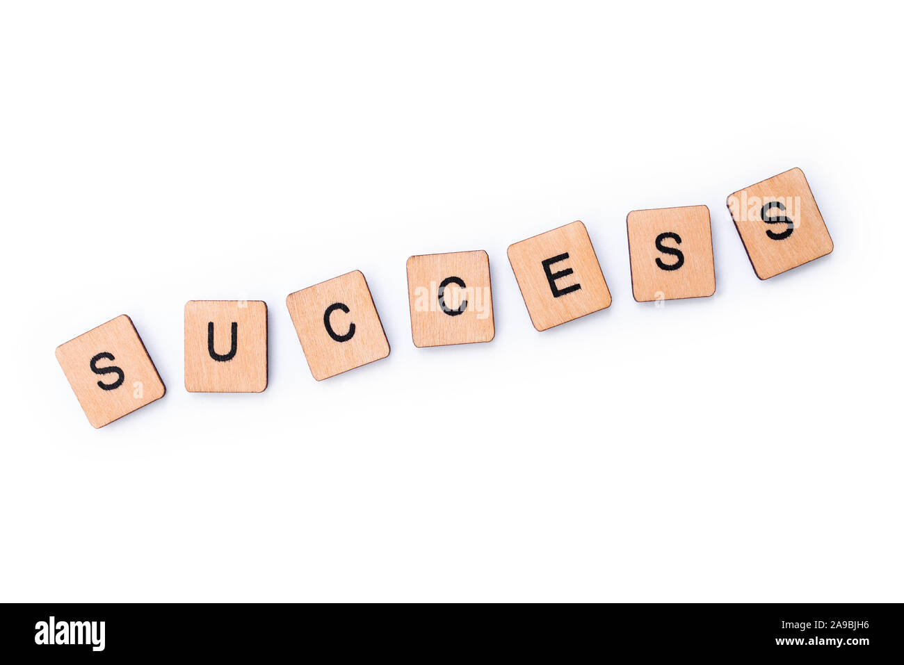 The word SUCCESS, spelt with wooden letter tiles over a white background. Stock Photo