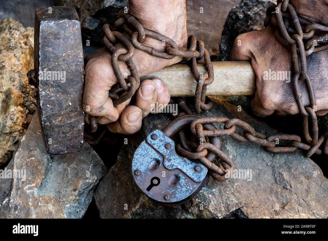 Slave chain tied hands hold a hammer. The desire to free oneself. Break the  shackles Stock Photo - Alamy