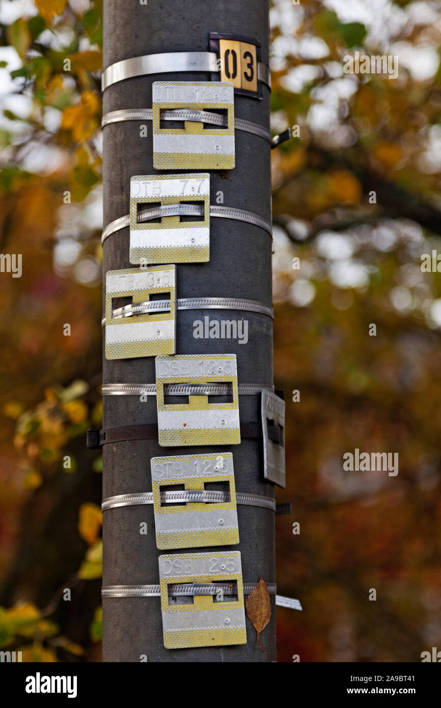 lots of metal trays with numbers and letters attached to a lamp post