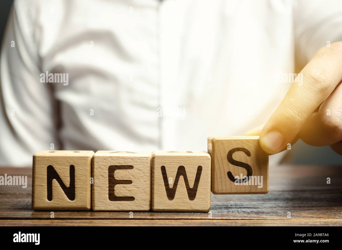 Journalist puts wooden blocks with the word News. Review the main events and analytics. Fake news. Information. The most important events in the count Stock Photo