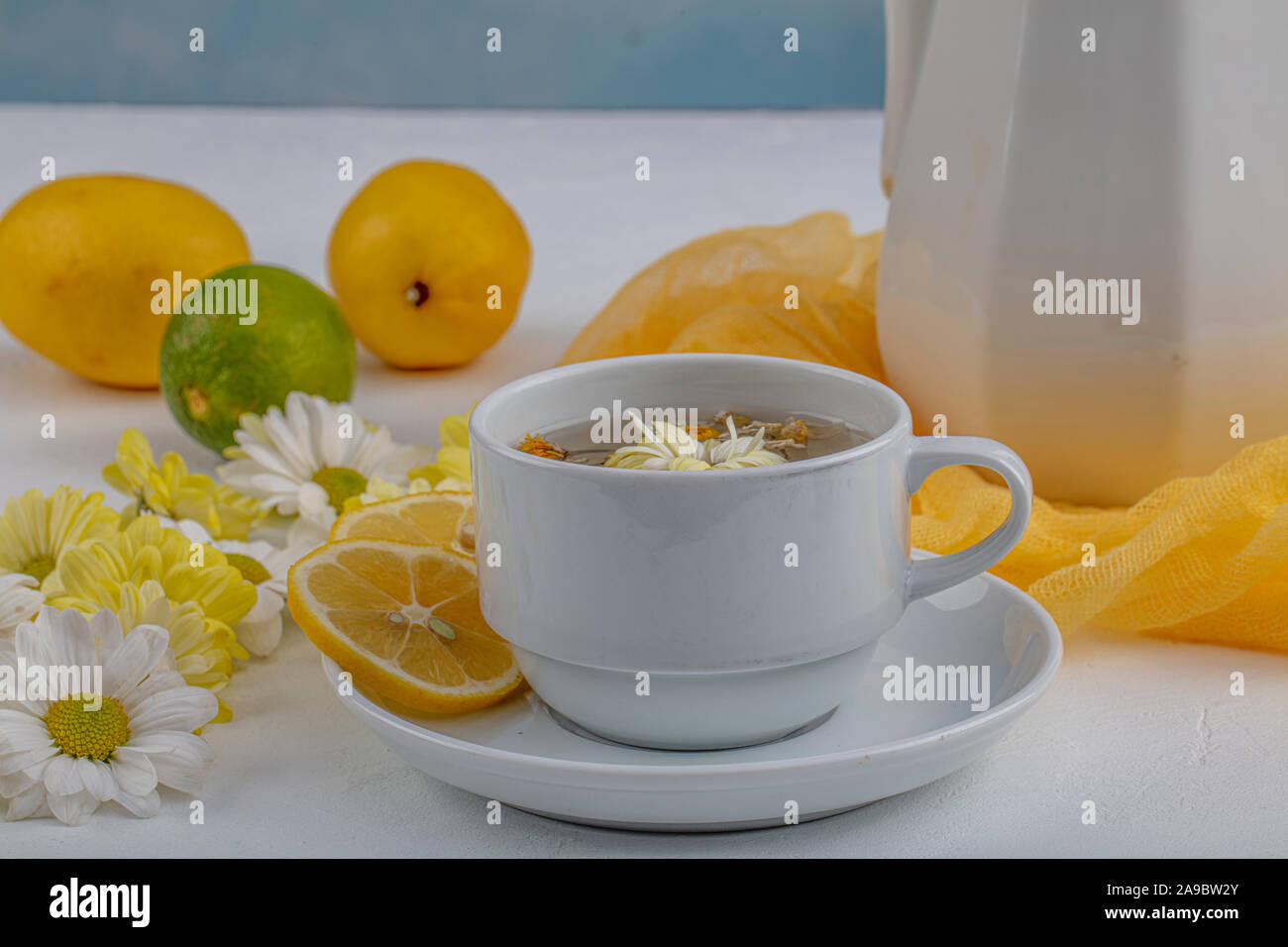 Glass cup with herbal tea with chamomile flowers on a white background ...