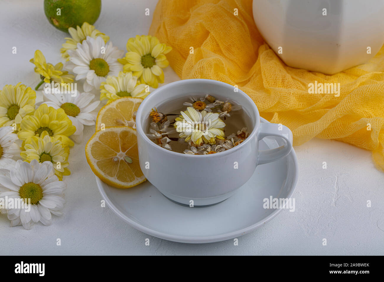 Glass cup with herbal tea with chamomile flowers on a white background ...
