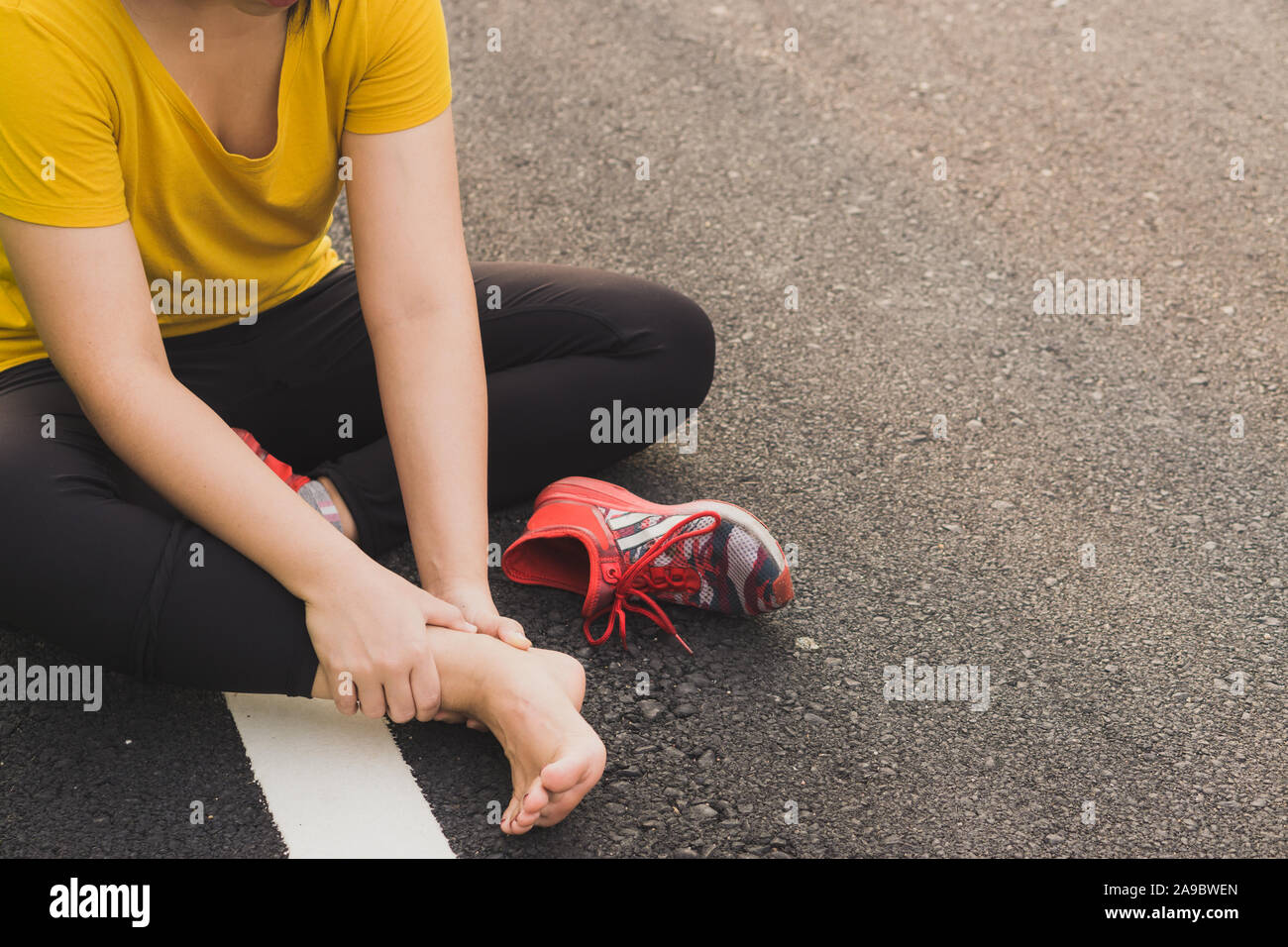 Ankle sprained. Young woman suffering from an ankle injury while ...