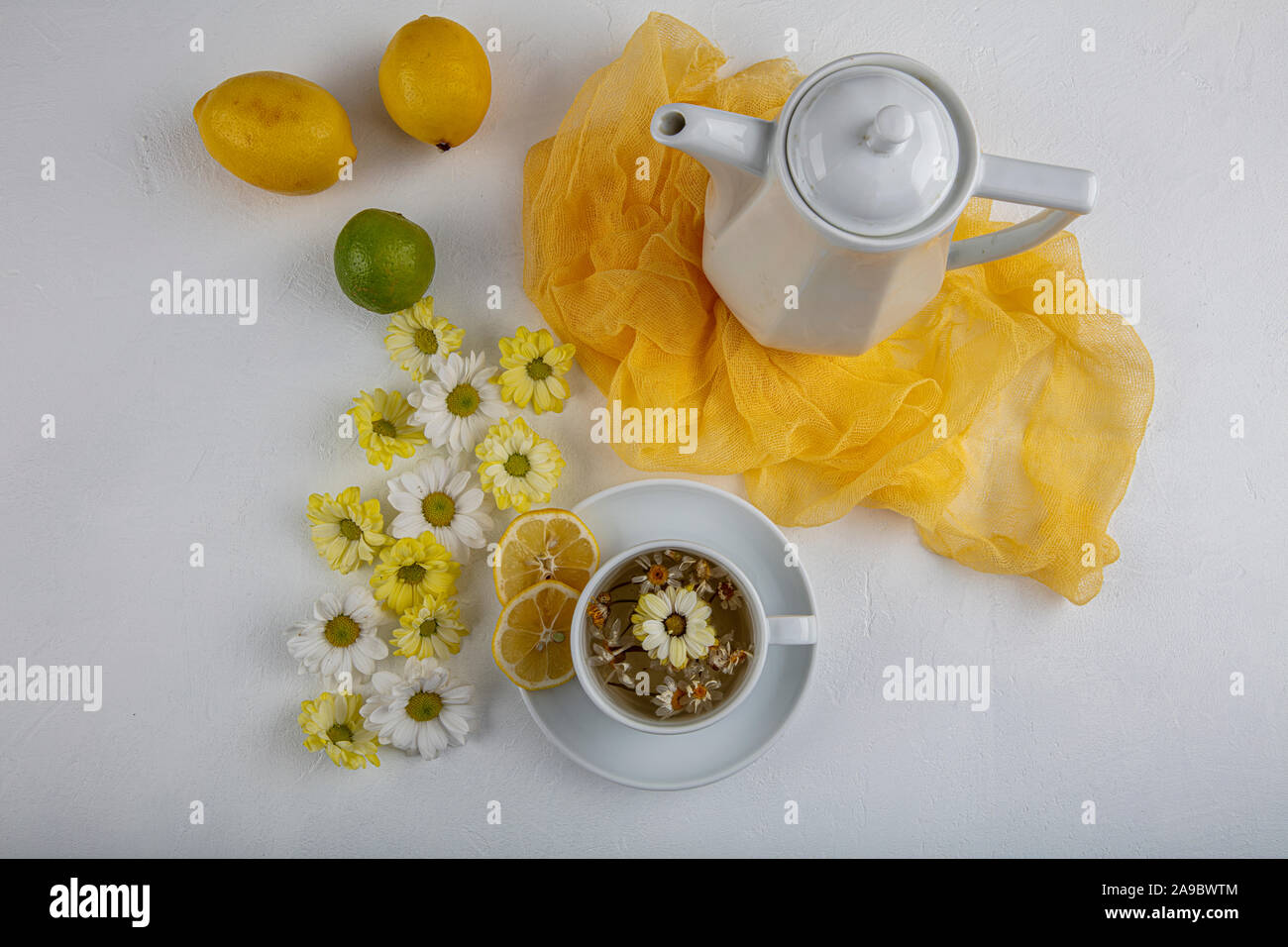 Glass cup with herbal tea with chamomile flowers on a white background ...