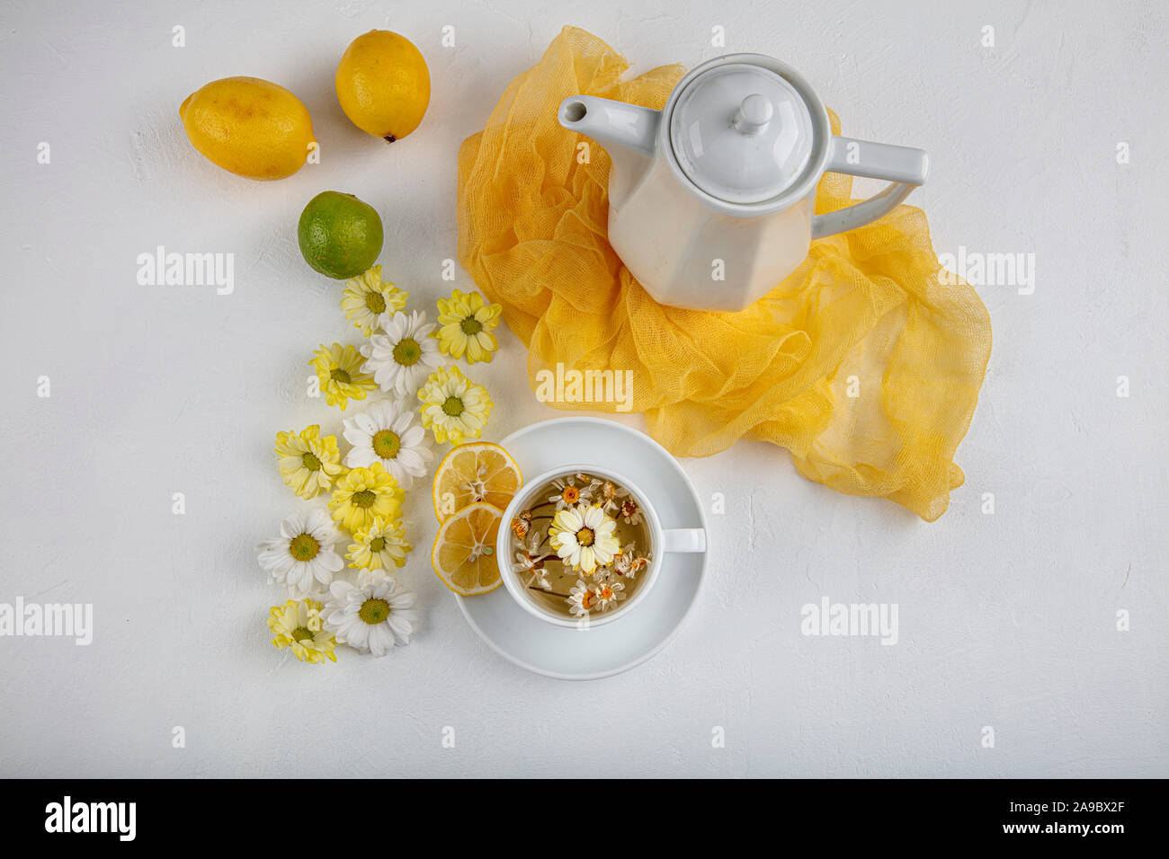 Glass cup with herbal tea with chamomile flowers on a white background ...