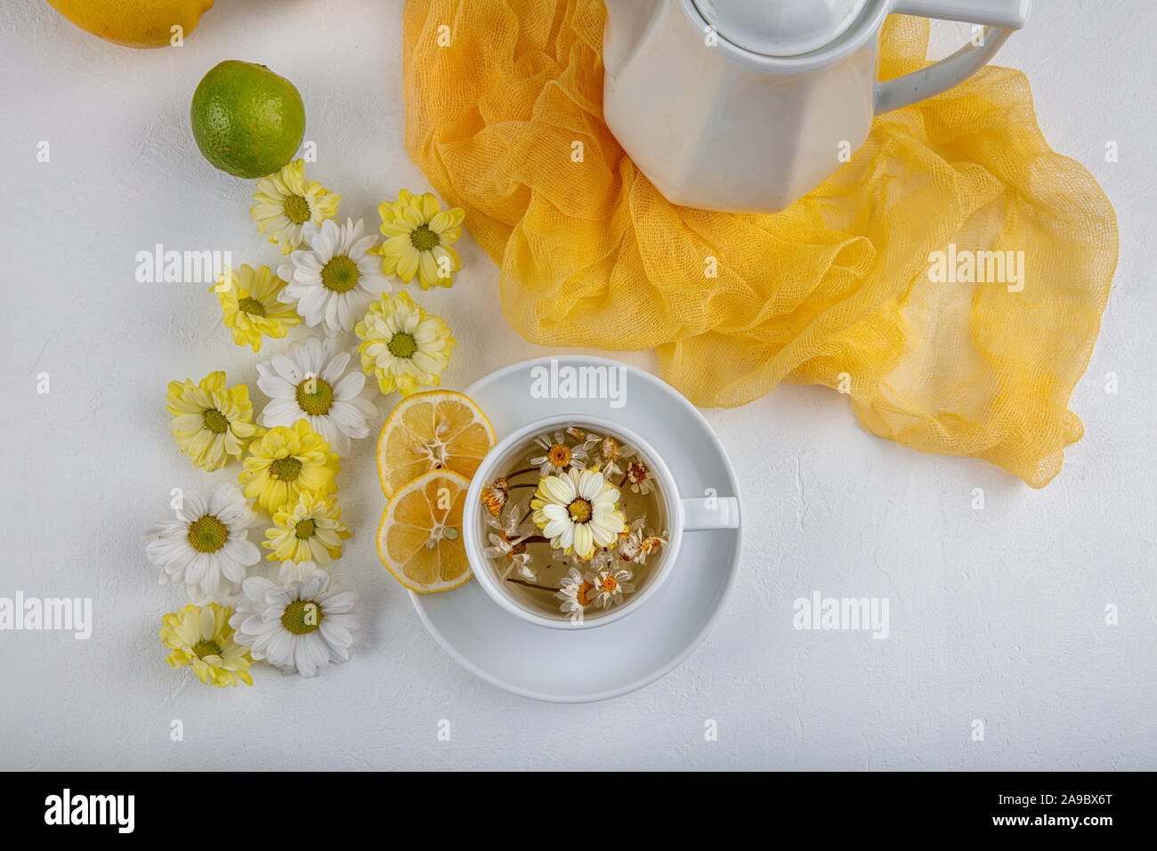 Glass cup with herbal tea with chamomile flowers on a white background ...