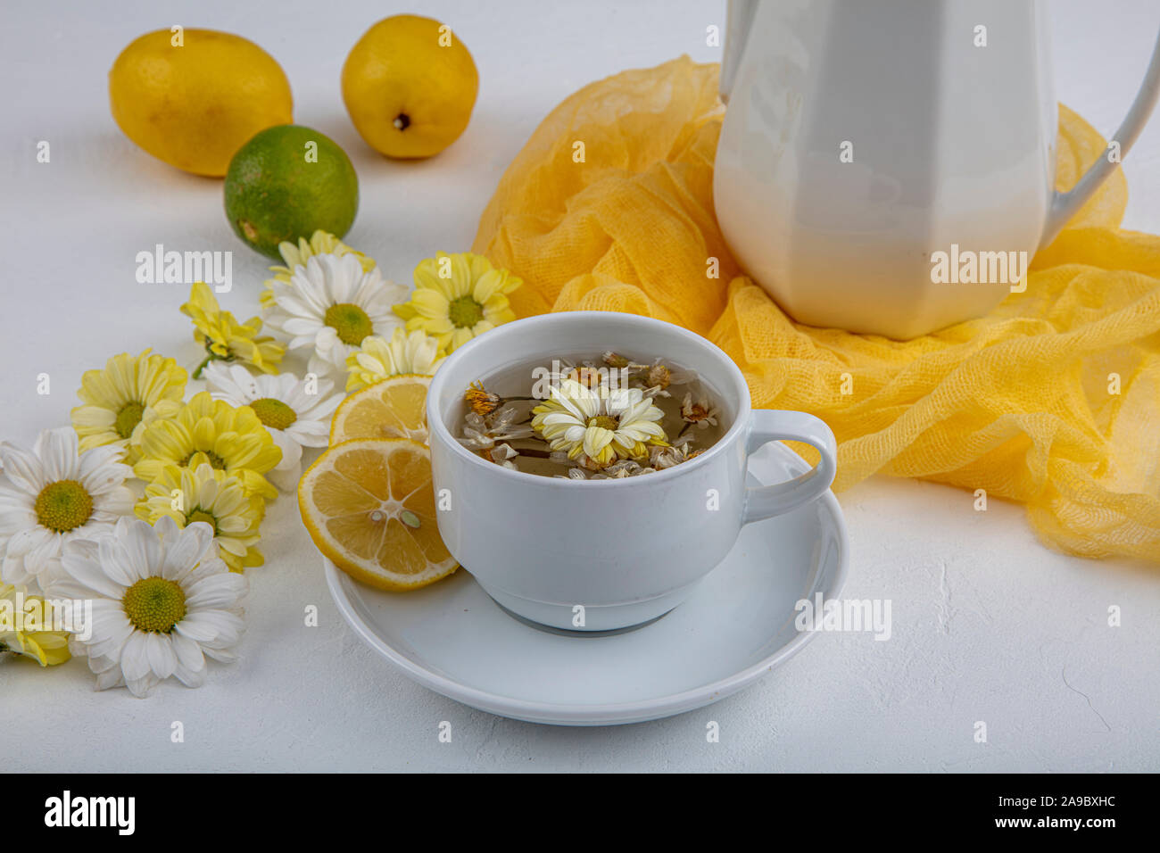 Glass cup with herbal tea with chamomile flowers on a white background ...