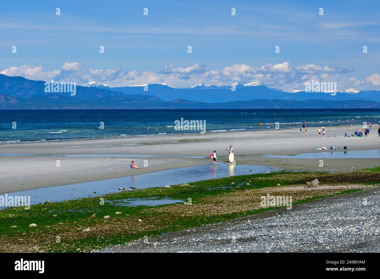 People enjoying a beautiful day relaxing and playing on Qualicum Beach on Vancouver Island British Columbia Canada. Stock Photo