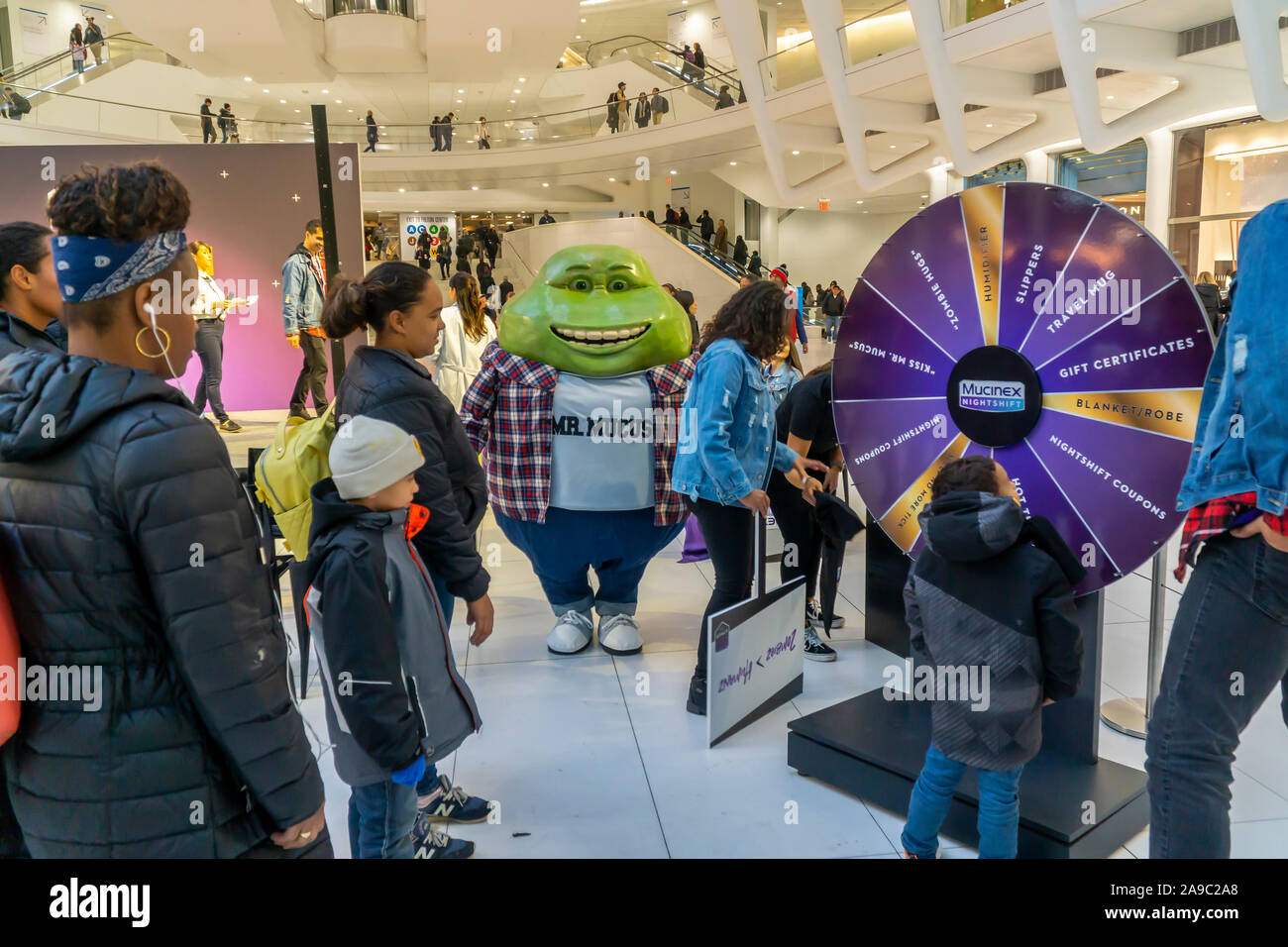 Mr. Mucus, mascot of Reckitt Benckiser’s Muciniex brand cold and cough medicine watches over participants spinning a wheel for prizes at a Mucinex branding event in the WTC Oculus in New York on Tuesday, November 12, 2019. (© Richard B. Levine) Stock Photo