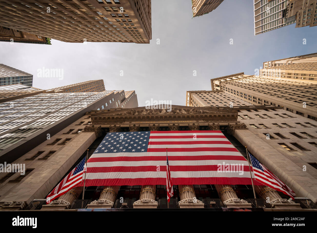 A giant American flag is unfurled across the facade of the New York Stock Exchange to commemorate Veterans Day in New York on Monday, November 11, 2019. Originally knows as Armistice Day, the holiday memorializes that on the eleventh hour of the eleventh day of the eleventh month the guns fell silent in1918 marking the end of World War I.  The holiday has since been expanded to include all American soldiers from all wars.(© Richard B. Levine) Stock Photo